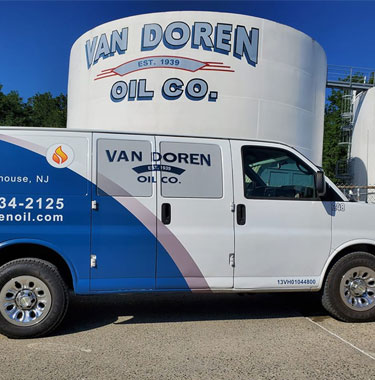 Van Doren Oil Company van in front of white oil storage containers